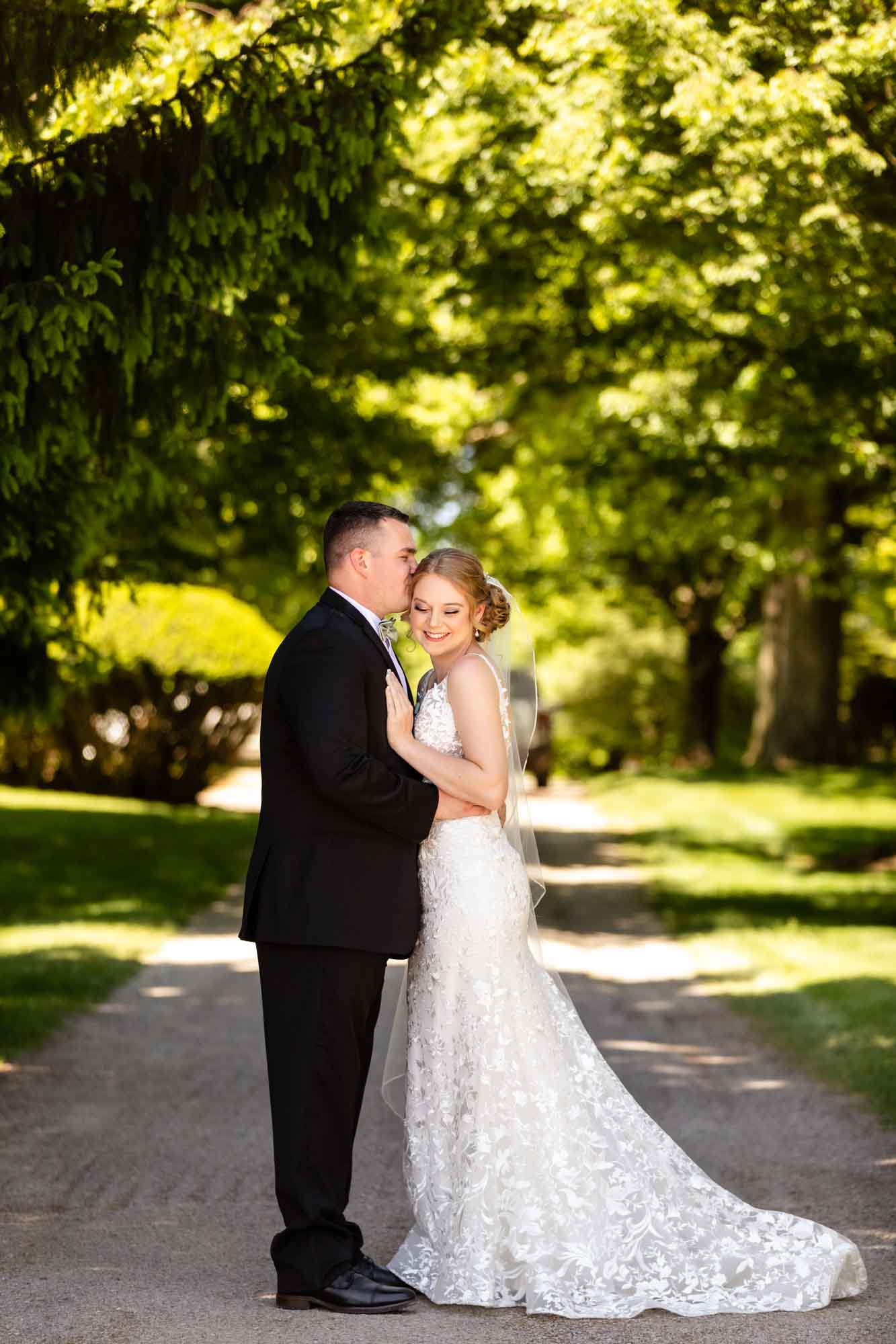 full length portrait of bride and groom standing in a tree lined path at their wedding venue, pinehall at eisler farms